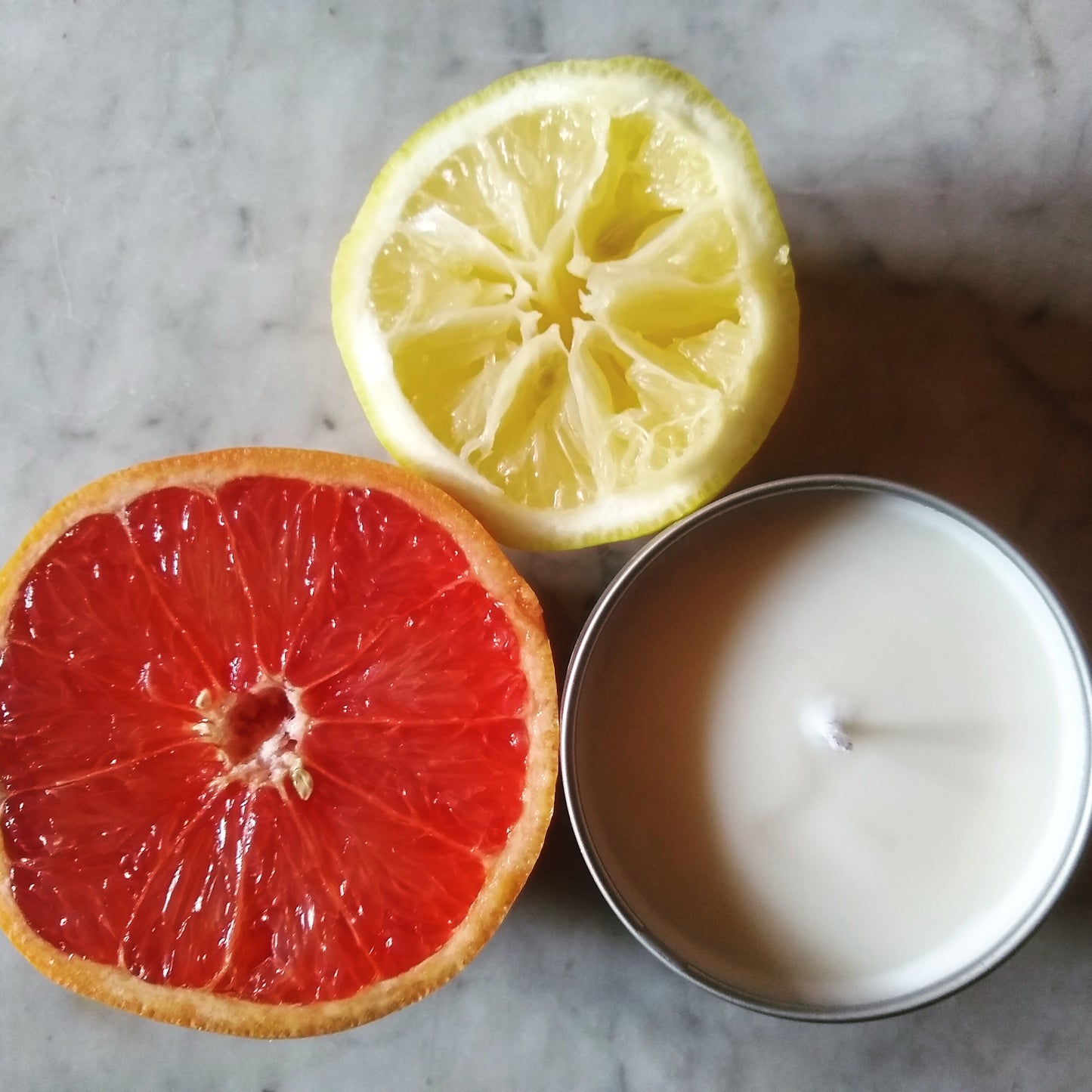 Juno luxury soy candle in a recyclable tin, a grapefruit and yuzu citrus fragrance inspired by Roman mythology, from Blessèd Hex